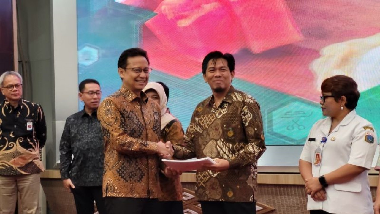 Penyerahan penghargaan kepada Dinas Kesehatan (Dinkes) yang berprestasi oleh Menteri Kesehatan (Menkes) RI Budi Gunadi Sadikin (kiri) dalam acara peluncuran program Pemberian Makanan Tambahan (PMT) berbahan pangan lokal yang diadakan di Jakarta, Rabu (17/5/2023) (ANTARA/Sean Filo Muhamad)