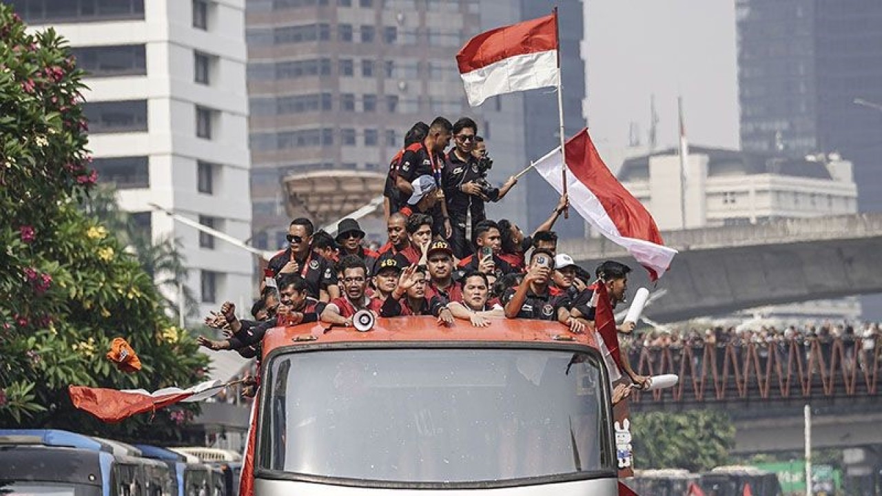 Pesepak bola Timnas Indonesia U-22 bersama ofisial dan pengurus PSSI berada di atas bus saat mengikuti arak-arakan di Jalan Jenderal Sudirman, Jakarta, Jumat (19/5/2023). ANTARA FOTO/Dhemas Reviyanto/rwa/pri.