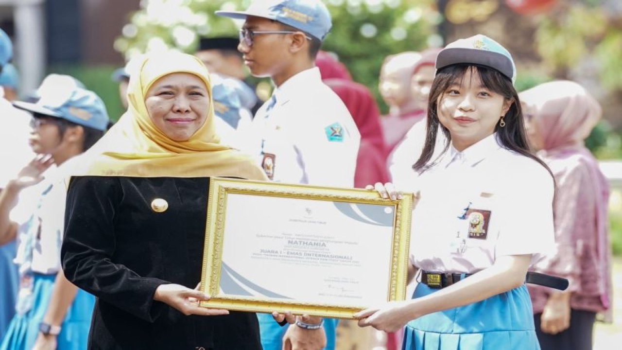 Gubernur Jatim Khofifah Indar Parawansa menyerahkan piagam penghargaan kepada salah satu siswa berprestasi saat peringatan Hari Pendidikan Nasional di halaman Gedung Negara Grahadi Surabaya, Selasa (2/4/2023). ANTARA/HO-Biro Adpim Jatim