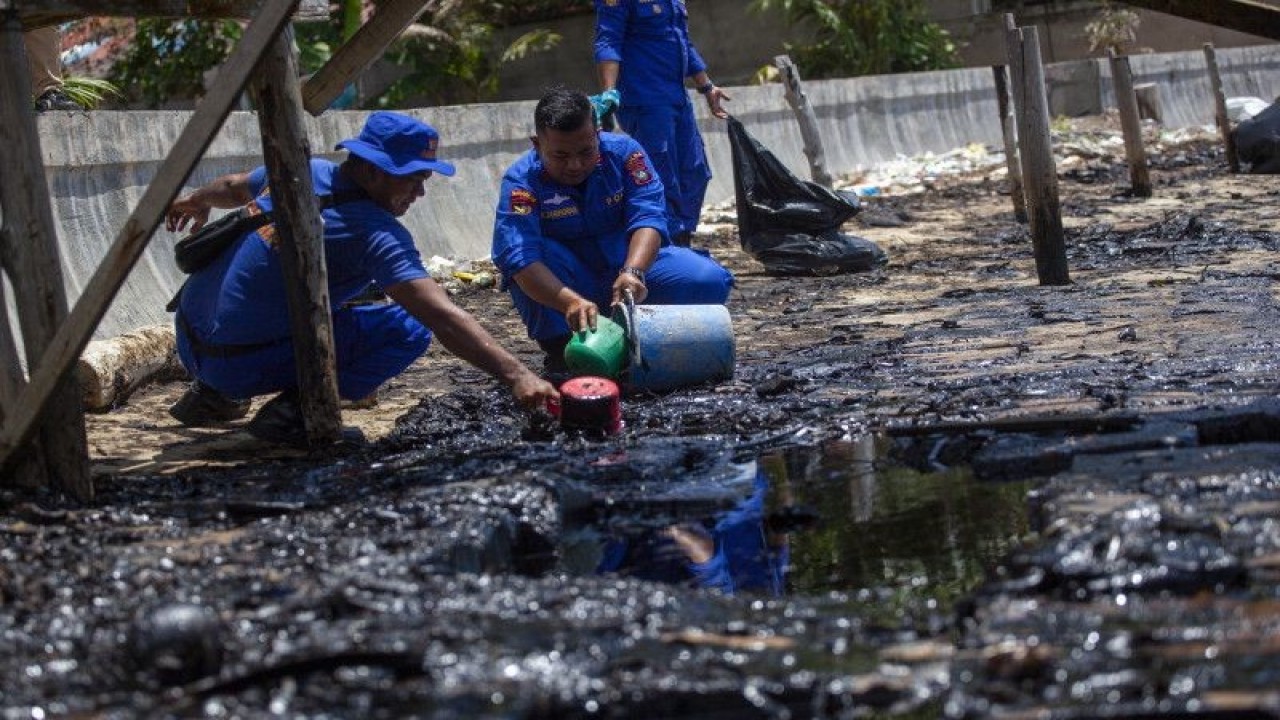 Petugas Kepolisian membersihkan limbah yang mencemari pantai di Kampung Melayu, Kelurahan Batu Besar, Kecamatan Nongsa, Kota Batam, Provinsi Kepulauan Riau, Kamis (4/5/2023). (ANTARA FOTO/Teguh Prihatna/foc)