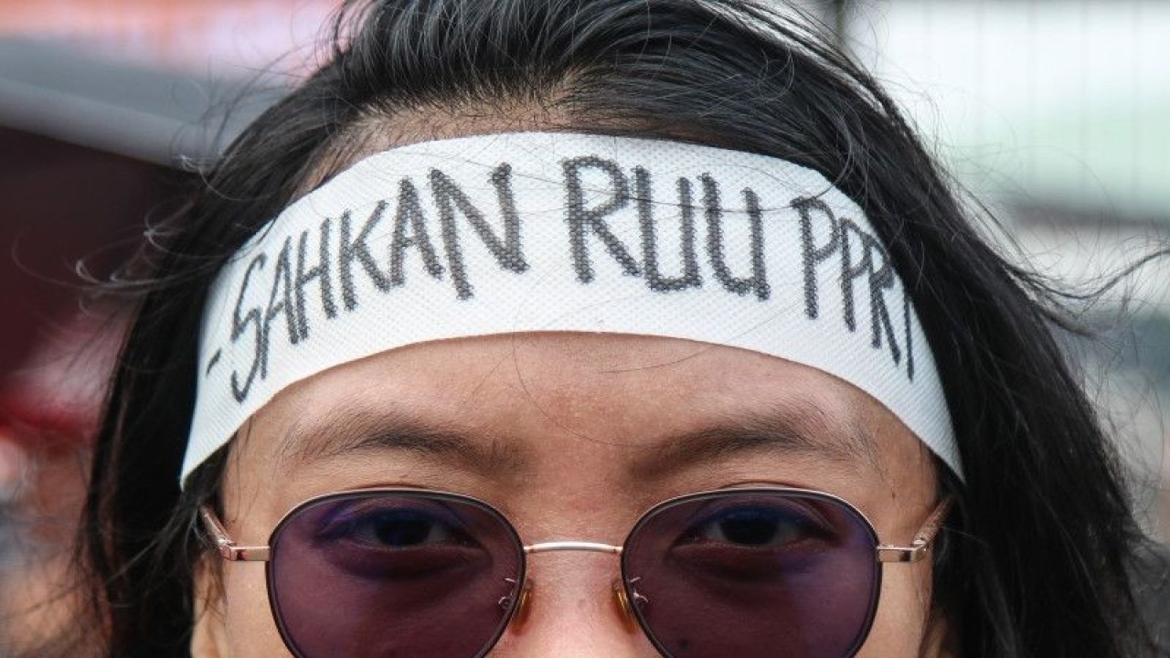 Seorang pengunjuk rasa dari Pekerja Rumah Tangga (PRT) mengenakan ikat kepala saat melakukan Aksi Tenda Perempuan di depan Gerbang DPR RI, Senayan, Jakarta, Sabtu (11/3/2023). . ANTARA FOTO/Prabanndaru Wahyuaji/foc (ANTARA FOTO/PRABANNDARU WAHYUAJI)