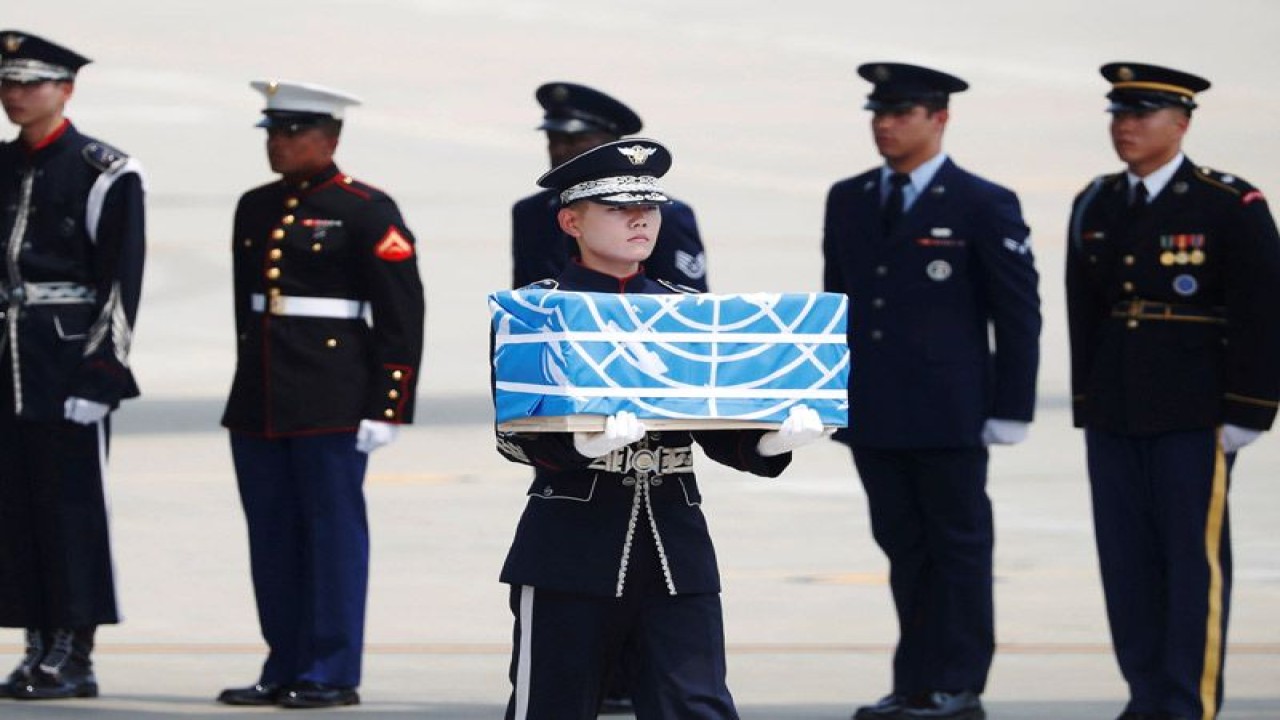 Seorang prajurit membawa sebuah peti berisi sisa jenazah prajurit Amerika Serikat yang tewas saat Perang Korea dalam sebuah upacara di Pangkalan Udara Osan di Pyeongtaek, Korea Selatan, Jumat (27/7/2018). (REUTERS/Kim Hong-Ji/Pool)