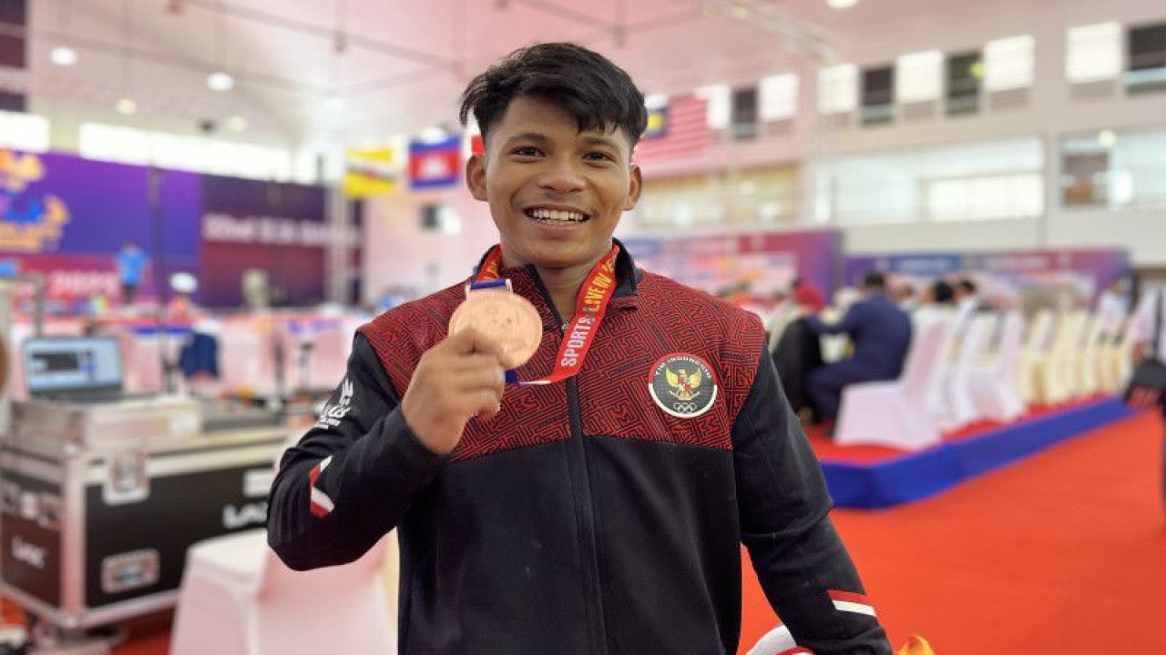 Lifter muda Indonesia Muhammad Husni berpose usai memenangkan medali perunggu pada cabang angkat besi 55 kg putra di SEA Games 2023 Kamboja, Sabtu (13/5/2023). (ANTARA/Arnidhya Nur Zhafira)