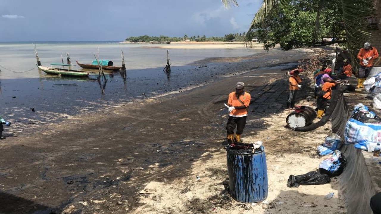 Petugas kebersihan membersihkan limbah minyak hitam di Pantai Melayu Kota Batam, Rabu (3/5). (ANTARA/Yude)