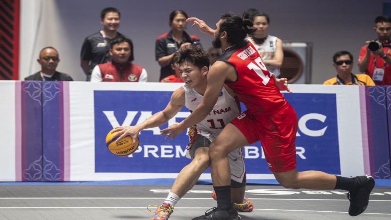 Pebasket Indonesia M Reza F Guntara (kanan) berusaha menghadang laju pebasket Vietnam Ban Vo Kim (kiri) saat pertandingan penyisihan grup A bola basket 3x3 putra SEA Games 2023 di Morodok Techno Elephant Hall, Kamboja, Sabtu (6/5/2023). ANTARA FOTO/M Agung Rajasa/tom.