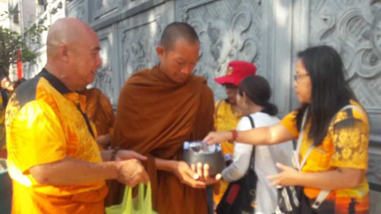 Seorang warga memberikan sedekah kepada biksu dalam pindapata di Magelang. ANTARA/Heru Suyitno