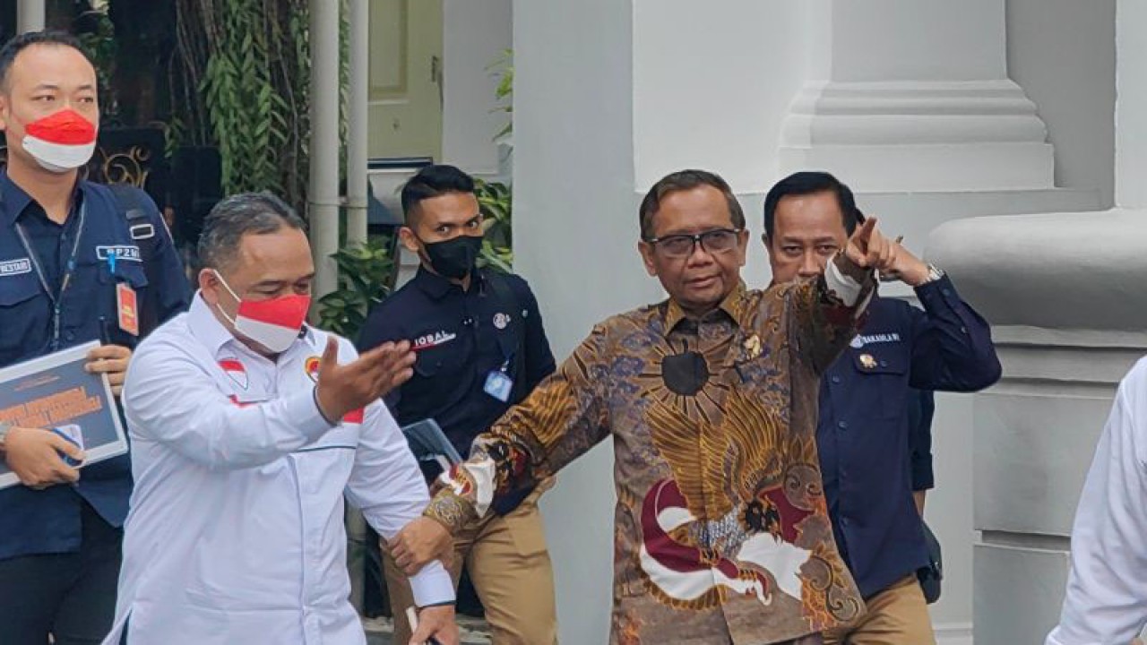 Menteri Koordinator Bidang Politik, Hukum, dan Keamanan Mahfud MD (kanan) menggandeng Kepala Badan Perlindungan Pekerja Migran Indonesia Benny Rhamdani selepas mengikuti rapat internal pemberantasan tindak pidana perdagangan orang di Istana Kepresidenan Jakarta, Selasa (30/5/2023). ANTARA/Gilang Galiartha