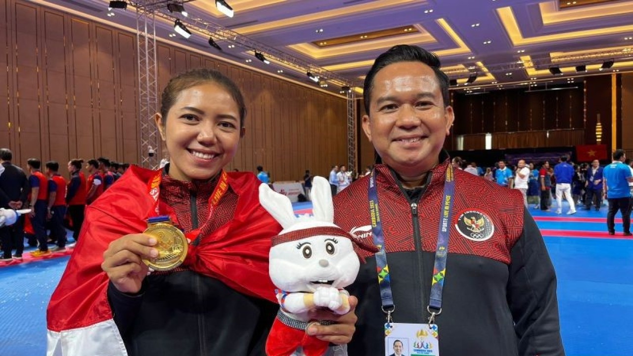 Atlet vovinam Indonesia Manik Trisna Dewi Wetan bergoto bersama Manager Timnas Vovinam Indonesia Isnaldi Muhammad Dini usai pengalungan medali di Chroy Changvar Convention Center Phnom Penh, Kamboja, Sabtu (6/5/2023). (ANTARA/Arnidhya Nur Zhafira)