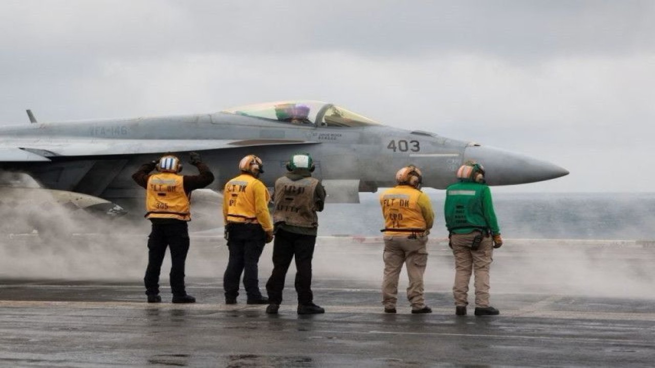 Arsip - Anggota kru memberi isyarat kepada jet tempur Super Hornet F/A-18E yang bersiap lepas landas untuk penerbangan rutin di atas kapal induk USS Nimitz milik AS di Laut China Selatan, 27 Januari 2023. (ANTARA/REUTERS /Joseph Campbell/as)