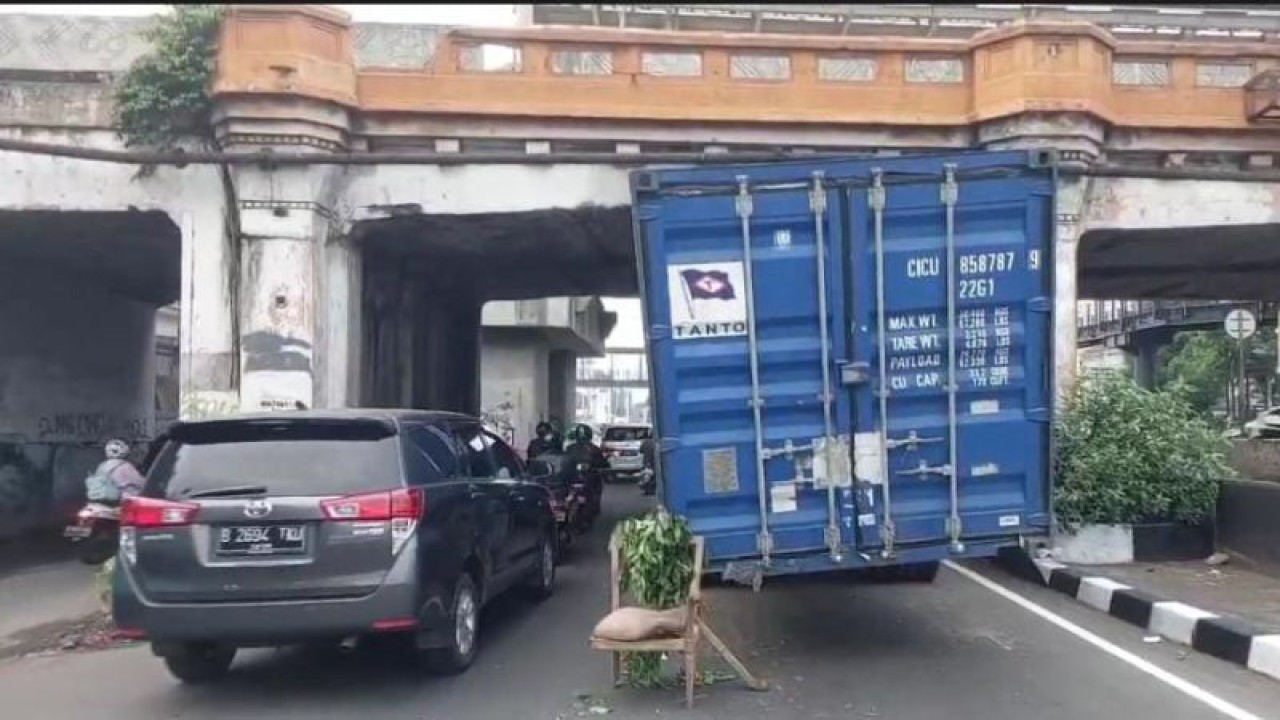 Sebuah truk kontainer bermuatan karpet tersangkut di kolong jembatan rel kereta Jalan Matraman Raya, Jakarta Timur, Selasa (23/5/2023). ANTARA/Syaiful Hakim