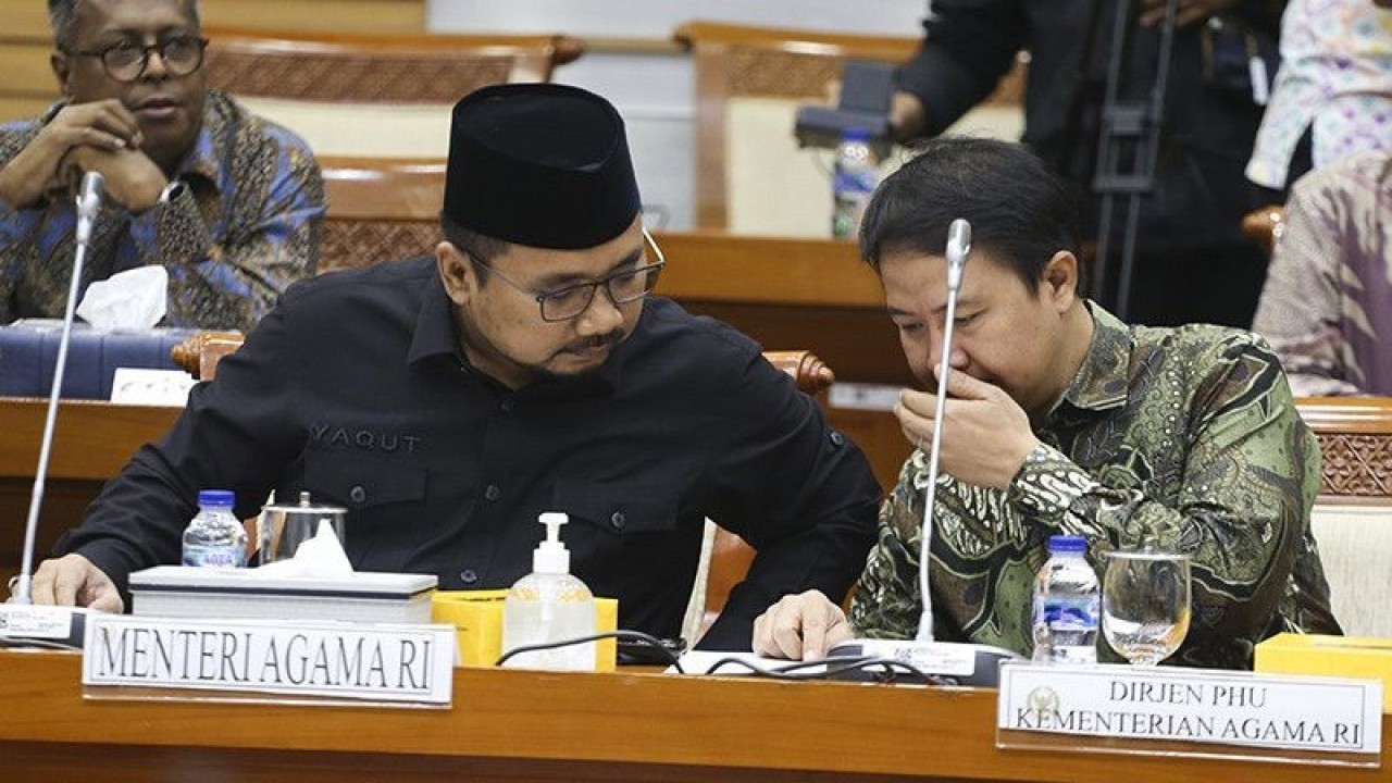 Menteri Agama Yaqut Cholil Qoumas (kiri) berbincang dan Direktur Jenderal Penyelenggaraan Haji dan Umrah Kementerian Agama Hilman Latief (kanan) sebelum rapat kerja bersama Komisi VIII DPR di Kompleks Parlemen, Senayan, Jakarta, Rabu (17/5/2023). (ANTARA FOTO/Rivan Awal Lingga/foc/aa)