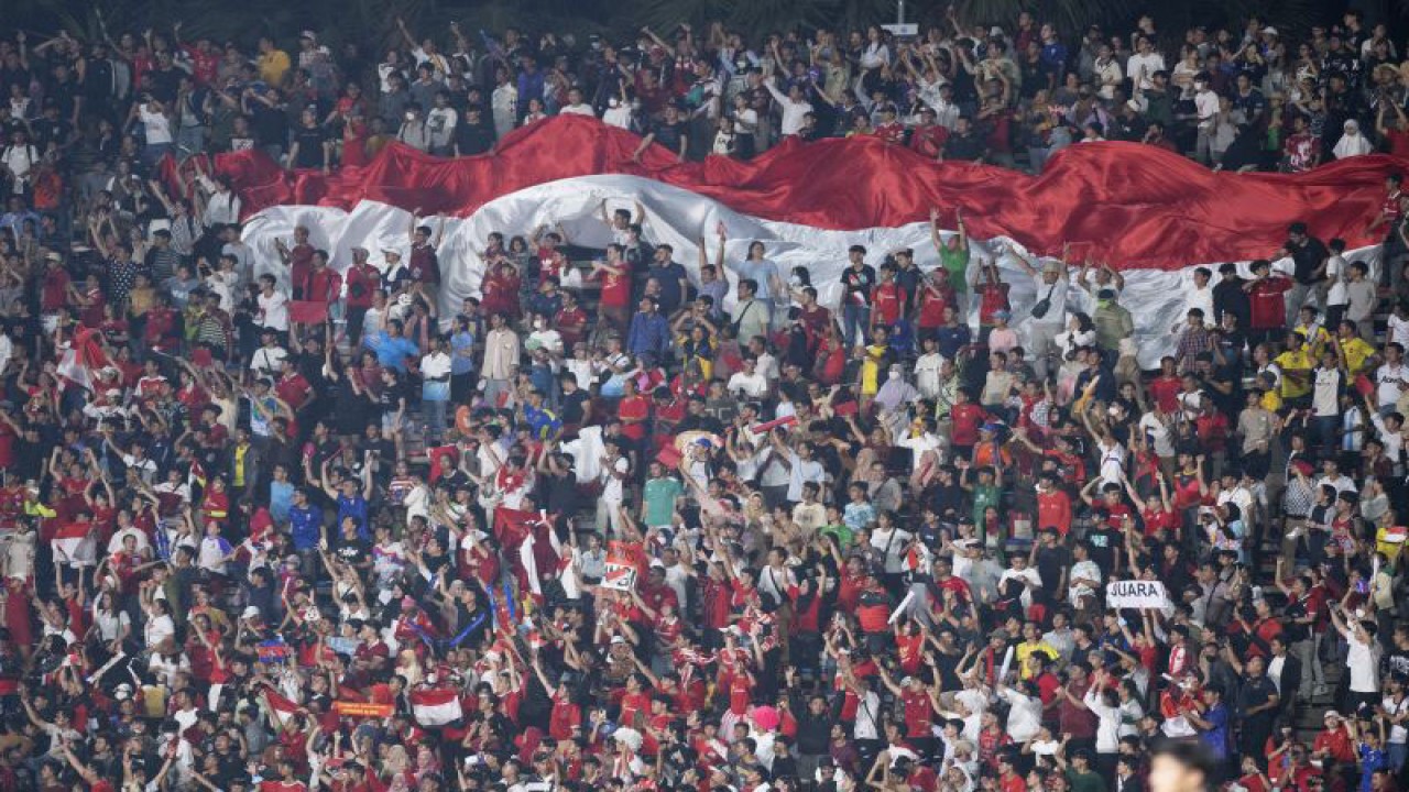Suporter Indonesia membentangkan bendera Merah Putih raksasa saat memberi dukungan terhadap Timnas Indonesia U-22 pada pertandingan Final Sepak Bola SEA Games 2023 di National Olympic Stadium, Phnom Penh, Kamboja, Selasa (16/5/2023). . ANTARA FOTO/M Agung Rajasa/rwa.