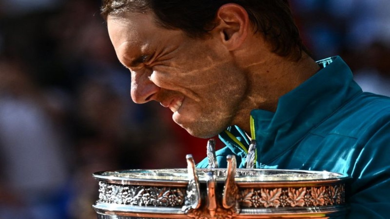 Petenis Spanyol Rafael Nadal memboyong trofi The Musketeers setelah mengalahkan petenis Norwegia Casper Ruud di final tunggal putra Roland-Garros Open, Court Philippe-Chatrier, Paris. (5/6/2022). (ANTARA/AFP/ANNE-CHRISTINE POUJOULAT)