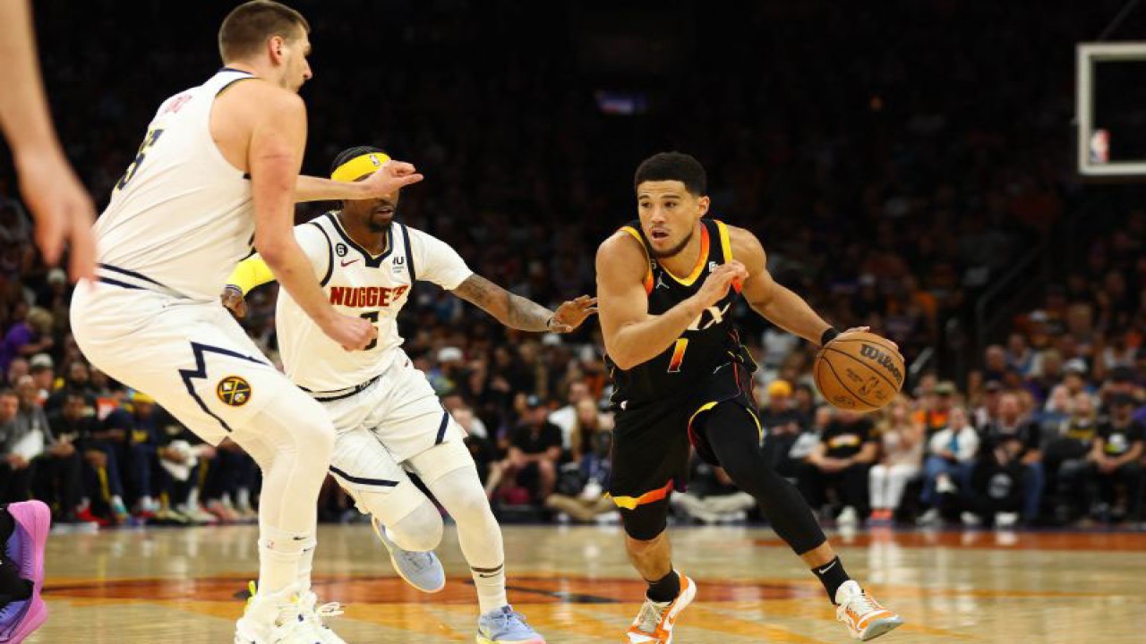 Pebasket Phoenix Suns Devin Booker (kanan) mendribel bola dan beruay melewati penjagaan pebasket Denver Nuggets dalam laga Playoff NBA 2023, di Footprint Center, Phoenix, Arizona, Amerika Serikat, Minggu (7/5/2023). Phoenix Suns berhasil mengalahkan Denver Nuggets 129 - 124ANTARA FOTO/Reuters-Mark J. Rebilas-USA TODAY Sports/hp.