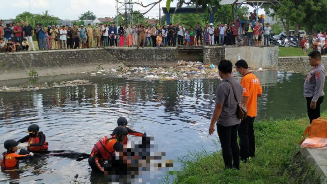 Petugas SAR mengevakuasi mayat pria tanpa identitas di pintu air kawasan Sungai Pesongoran, Mataram, NTB, Selasa (22/5/2023). ANTARA/HO-Polresta Mataram.