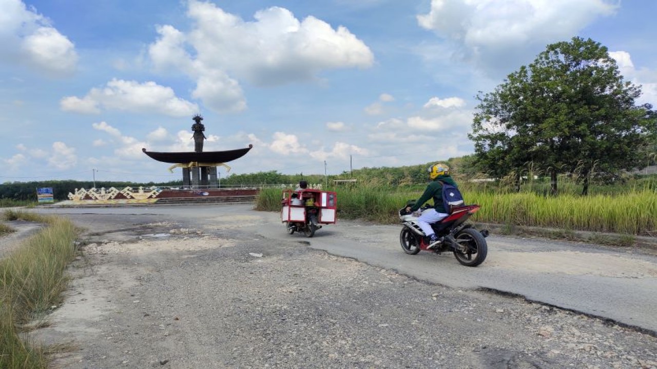 Pengguna motor sedang melintasi jalan rusak yang berada di Jalan Terusan Endro Suratmin, akses utama ke Desa Sabah Balau, Lampung Selatan. (ANTARA/Dian Hadiyatna)