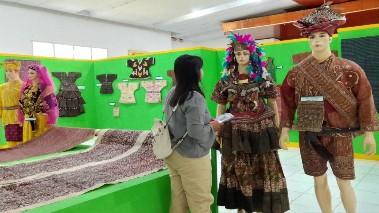 Pengunjung melihat kain dan baju tradisional yang dipamerkan di UPT Taman Budaya dan Museum di Palu, Senin (29/5/2023). (ANTARA/Nur Amalia Amir)