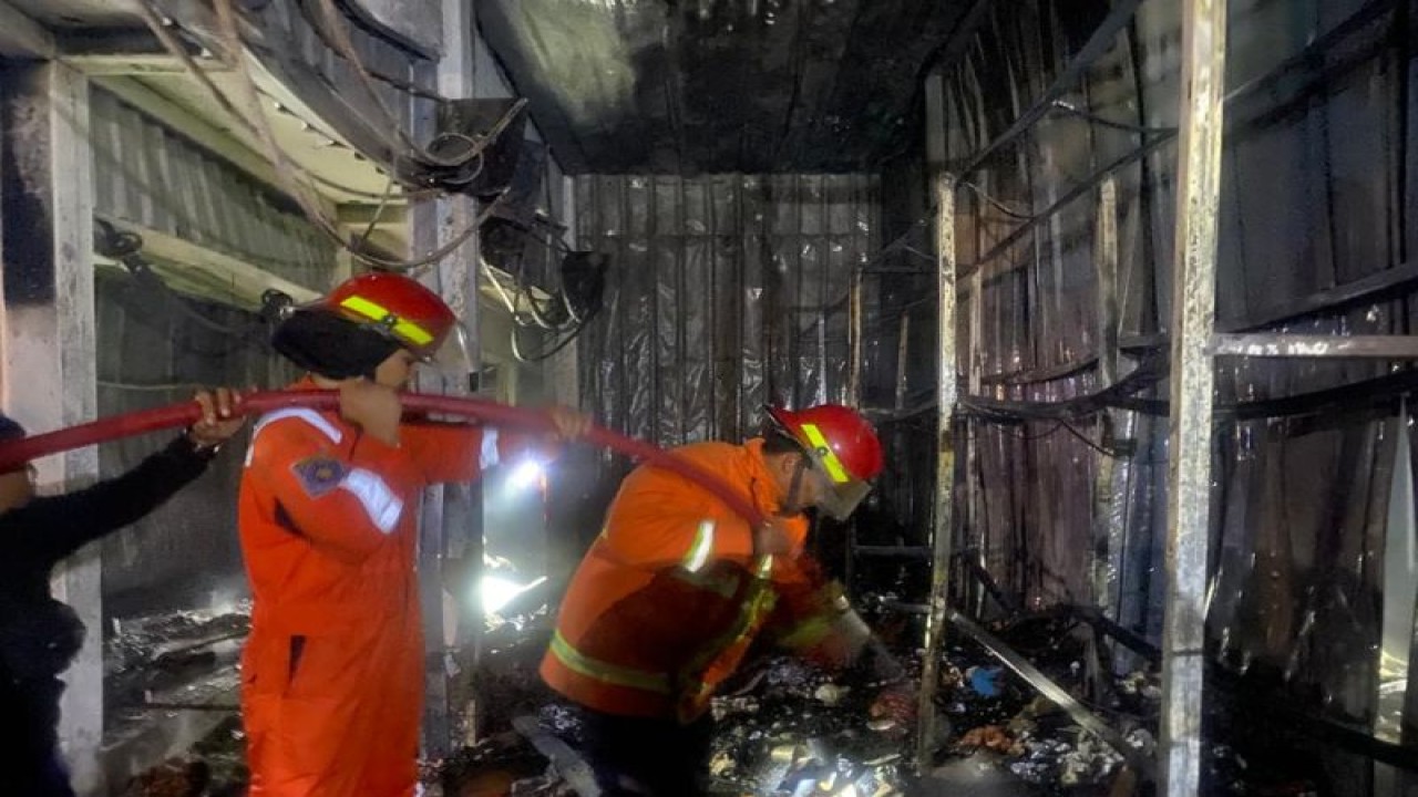 Petugas damkar berjibaku memadamkan kobaran api yang membakar belasan kios di Pasar Arjosari Pacitan, Minggu (28/5/2023) (ANTARA/HO - Unit Damkar Pacitan)
