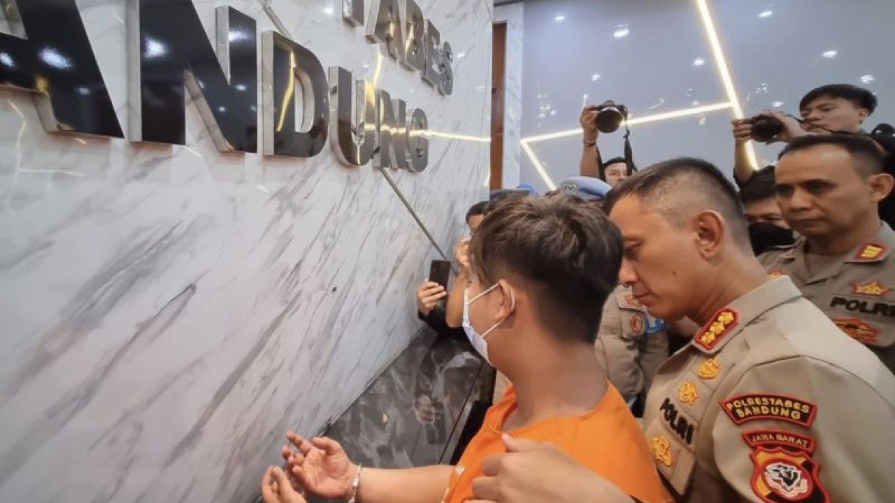 Pedagang Pasar Cimol Gedebage berinisial YH yang menjadi tersangka pengancaman warga menggunakan pisau diamankan polisi di Polrestabes Bandung, Kota Bandung, Jawa Barat, Jumat (12/5/2023). (ANTARA/Bagus Ahmad Rizaldi)