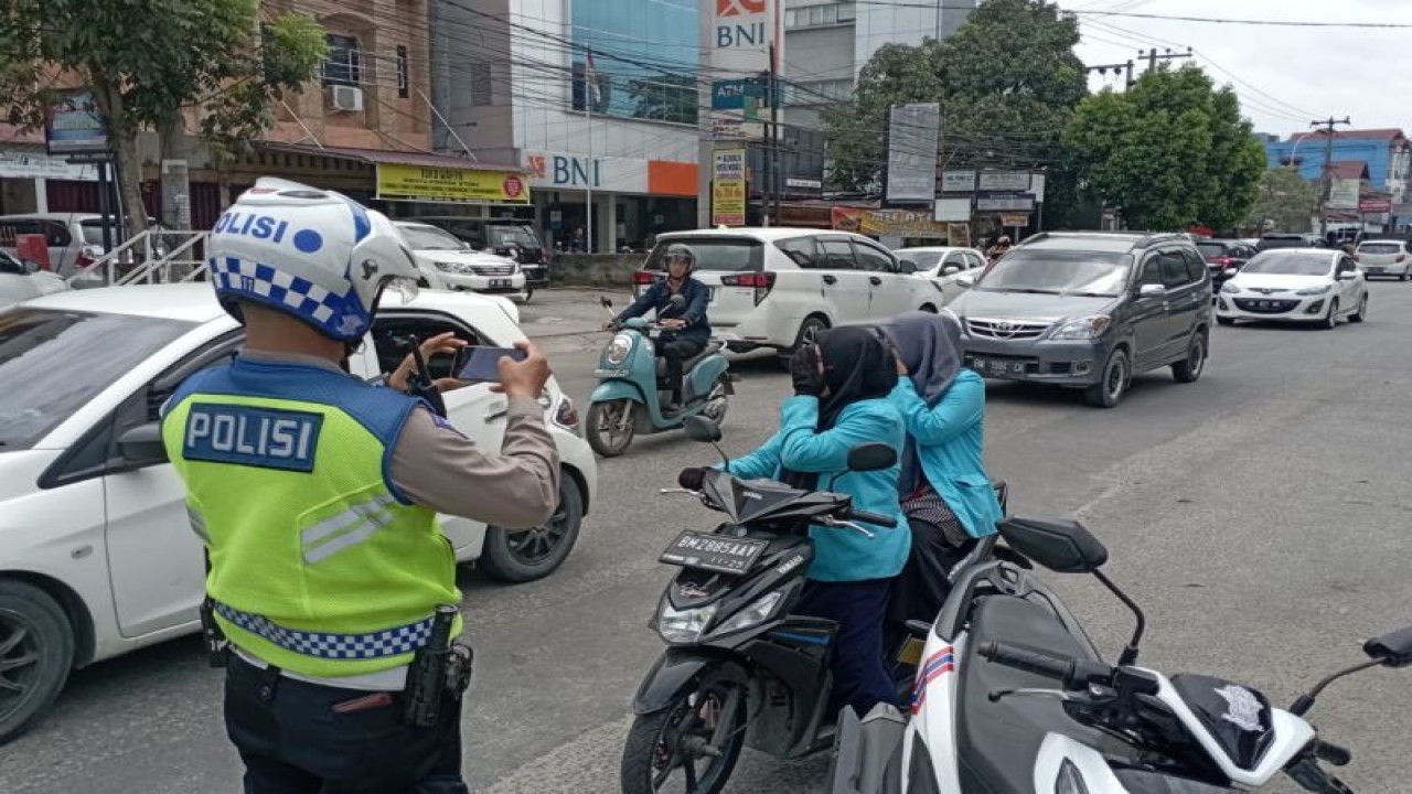 Anggota Satlantas Polresta Pekanbaru sedang menindak pelanggar lalu lintas dengan cara menggunakan kamera secara mobile belum lama ini. ANTARA/HO-Polresta Pekanbaru.