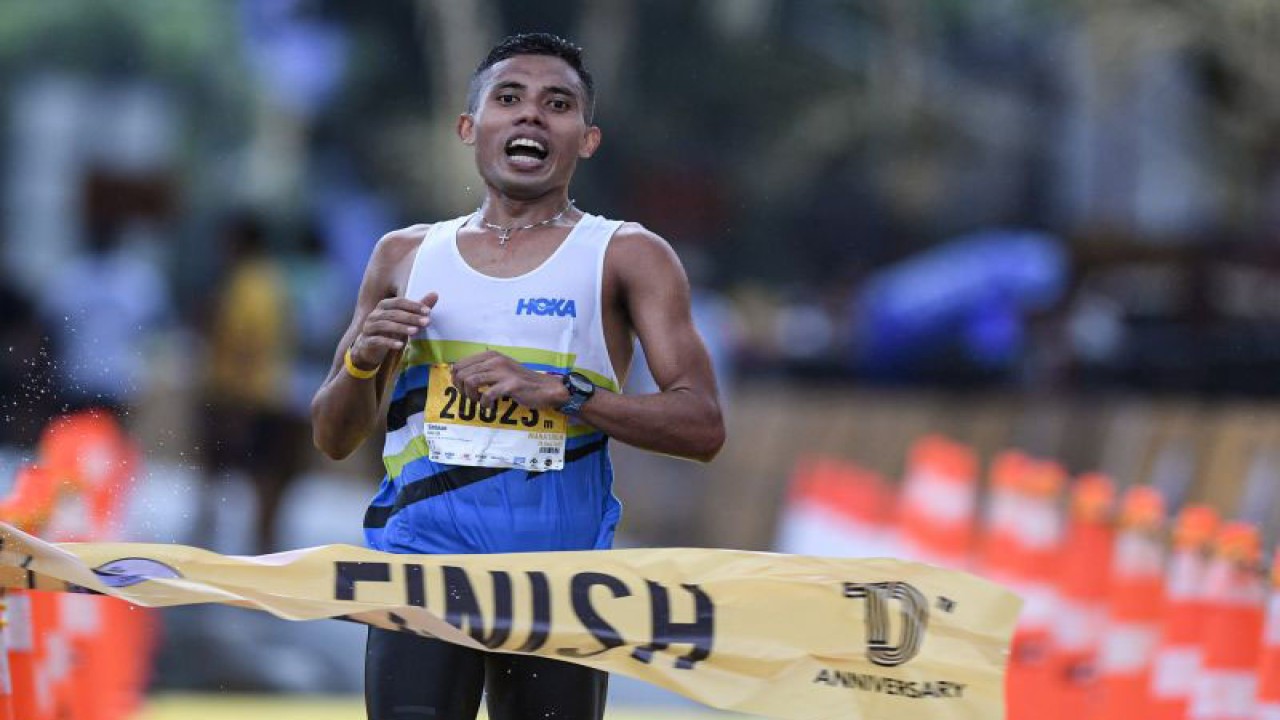 Arsip - Pelari nasional Rikki Marthin Luther Simbolon berlari menuju garis finish pada marathon kategori nasional pada ajang Maybank Marathon 2022 di kawasan Gianyar, Bali, Minggu (28/8/2022). . ANTARA FOTO/Fauzan/nym.