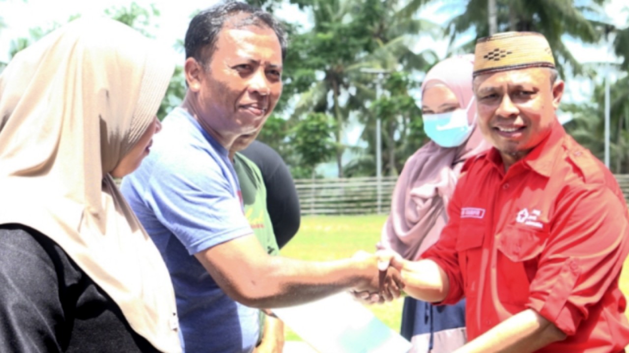 Sekretaris Daerah (Sekda) Kabupaten Gorontalo, Roni Sampir (kanan) menyerahkan sertifikat tanah kepada warga di Desa Molas, Kabupaten Gorontalo. ANTARA/HO