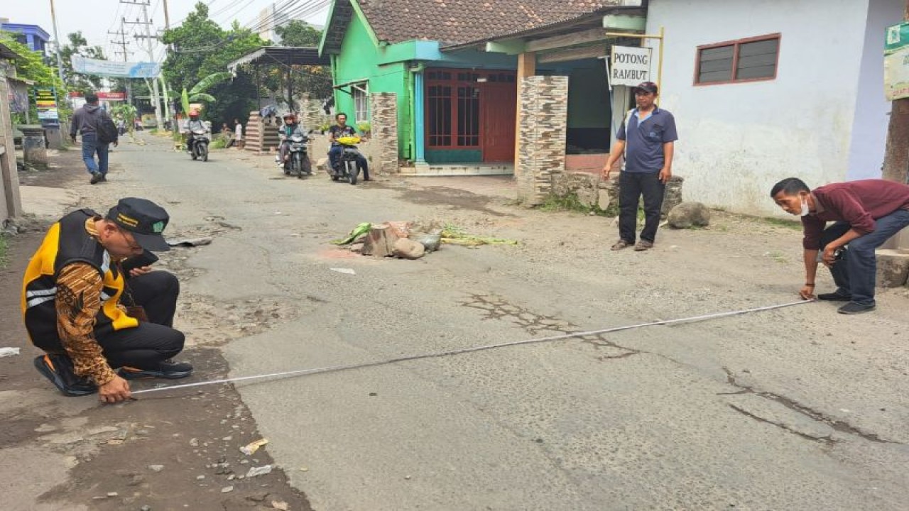 Petugas PU Bina Marga SDA Kabupaten Sidoarjo melakukan pengukuran perbaikan jalan rusak di kabupaten setempat, Selasa (9/5/2023). ANTARA/HO-Pemkab Sidoarjo