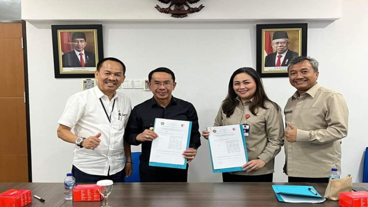 Bupati Sigi Mohamad Irwan (kanan) foto bersama Sekretaris LPTTN Priscilia Waworuntu sambil menunjukan naskah kerja sama yang ditandatangani dua pihak. (ANTARA/HO-Dok Prokopim Setda Pemkab Sigi)