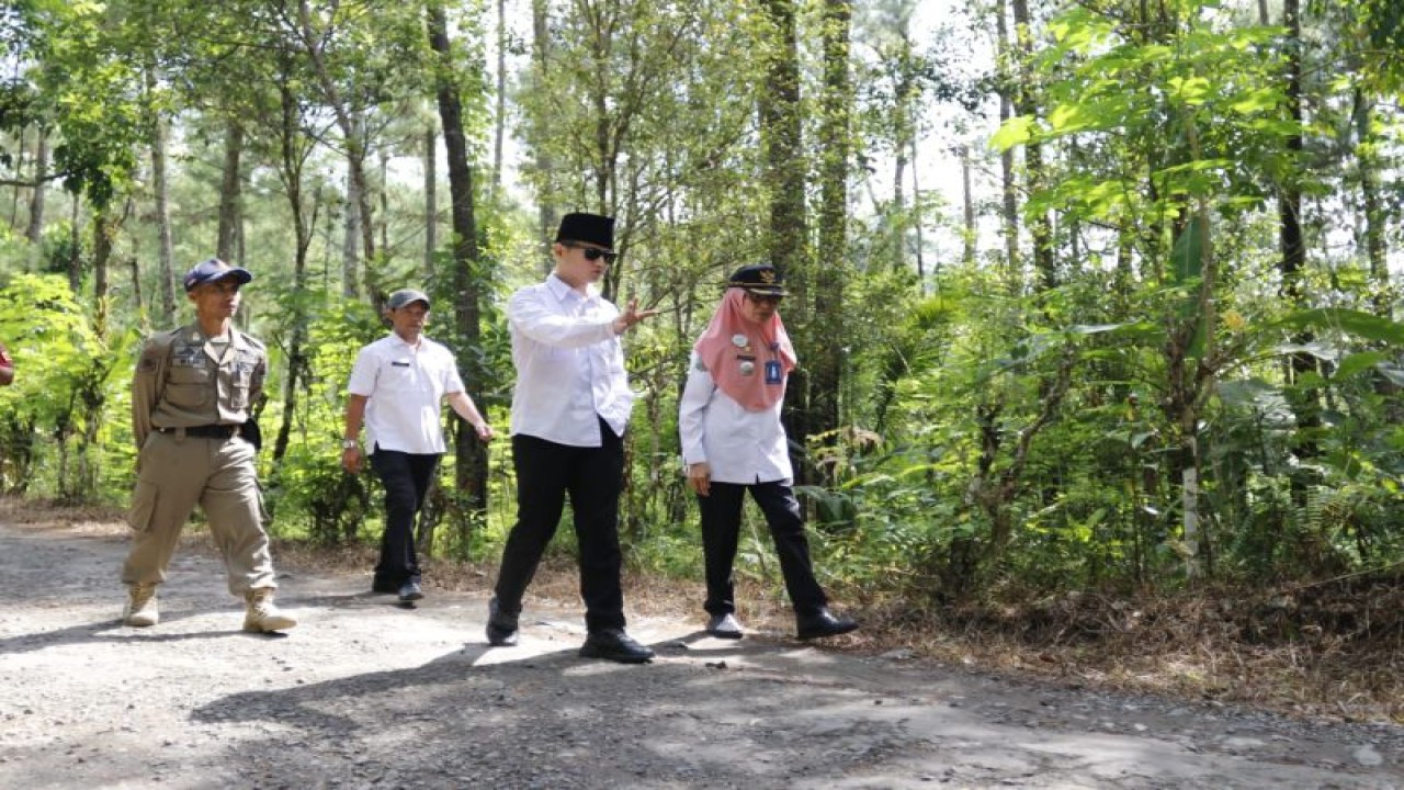 Bupati Trenggalek Mochamad Nur Arifin (kedua kanan) didampingi Camat Kampak Hasnawati (kanan) berjalan meninjau jalan rusak di Desa Ngadimulyo, bagian ruas jalur Kampak-Munjungan, di Ngadimulyo Trenggalek, Rabu (10/5/2023) (ANTARA/HO - Prokopim Trenggalek)