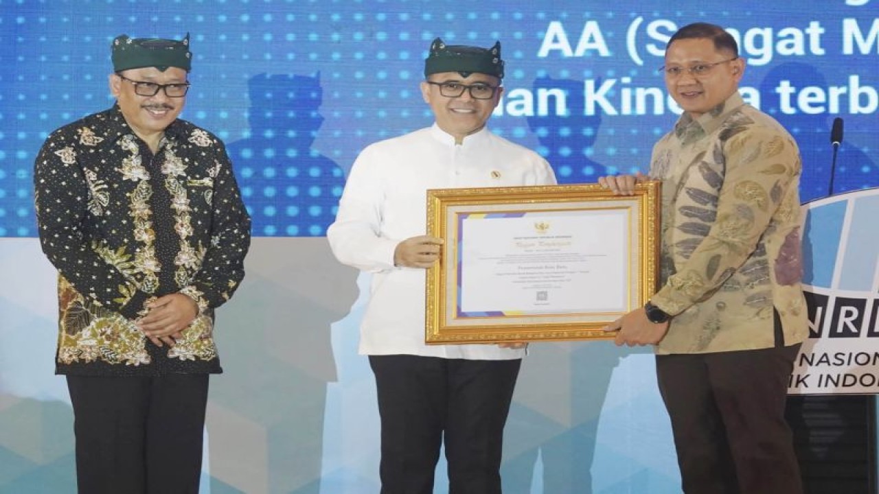 Penjabat Wali Kota Batu Aries Agung Paewai (kanan) menerima penghargaan peringkat 5 Nasional Pengawasan Kearsipan dari ANRI, yang diserahkan oleh Menpan-RB Abdullah Azwar Anas (tengah) di Banyuwangi, Jawa Timur, Senin (22/5/2023). (ANTARA/HO-Humas Pemkot Batu)