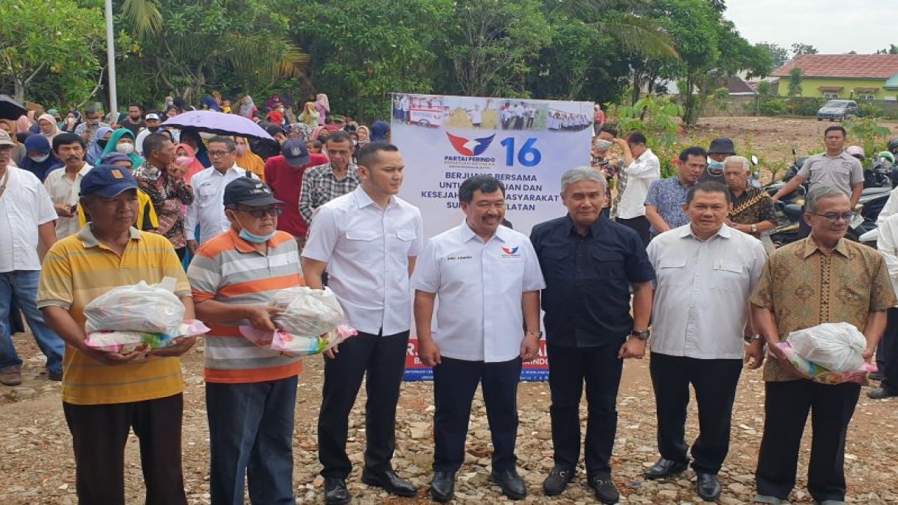 Pengurus Partai Perindo Andi Asmara didampingi tokoh masyarakat Sumsel Mularis Djahri membagikan 1.000 paket beras kepada warga Palembang. (ANTARA/Yudi Abdullah/23)
