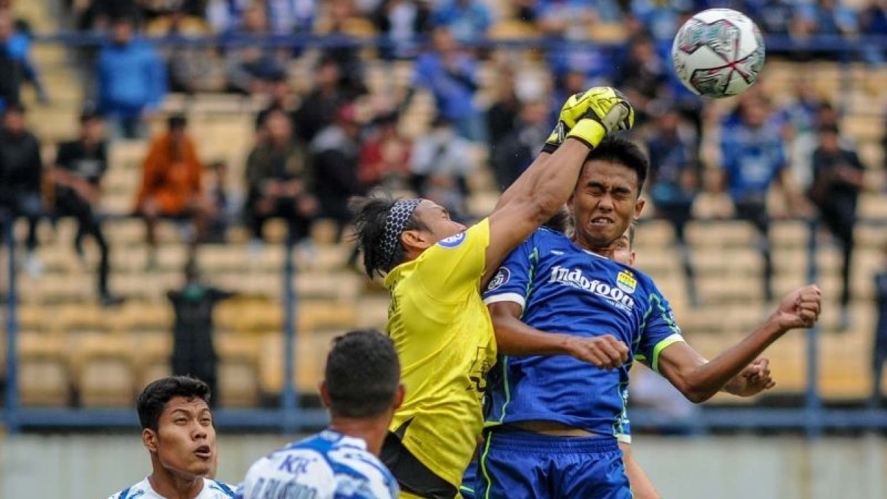 Arsip - Pesepak bola Persib Bandung Kakang Rudianto (kanan) berebut bola atas dengan penjaga gawang PSIS Semarang Wahyu Tri (tengah) saat pertandingan BRI Liga 1 di Stadion Gelora Bandung Lautan Api, Bandung, Jawa Barat, Sabtu (13/8/2022). ANTARA FOTO/Raisan Al Farisi/aww.