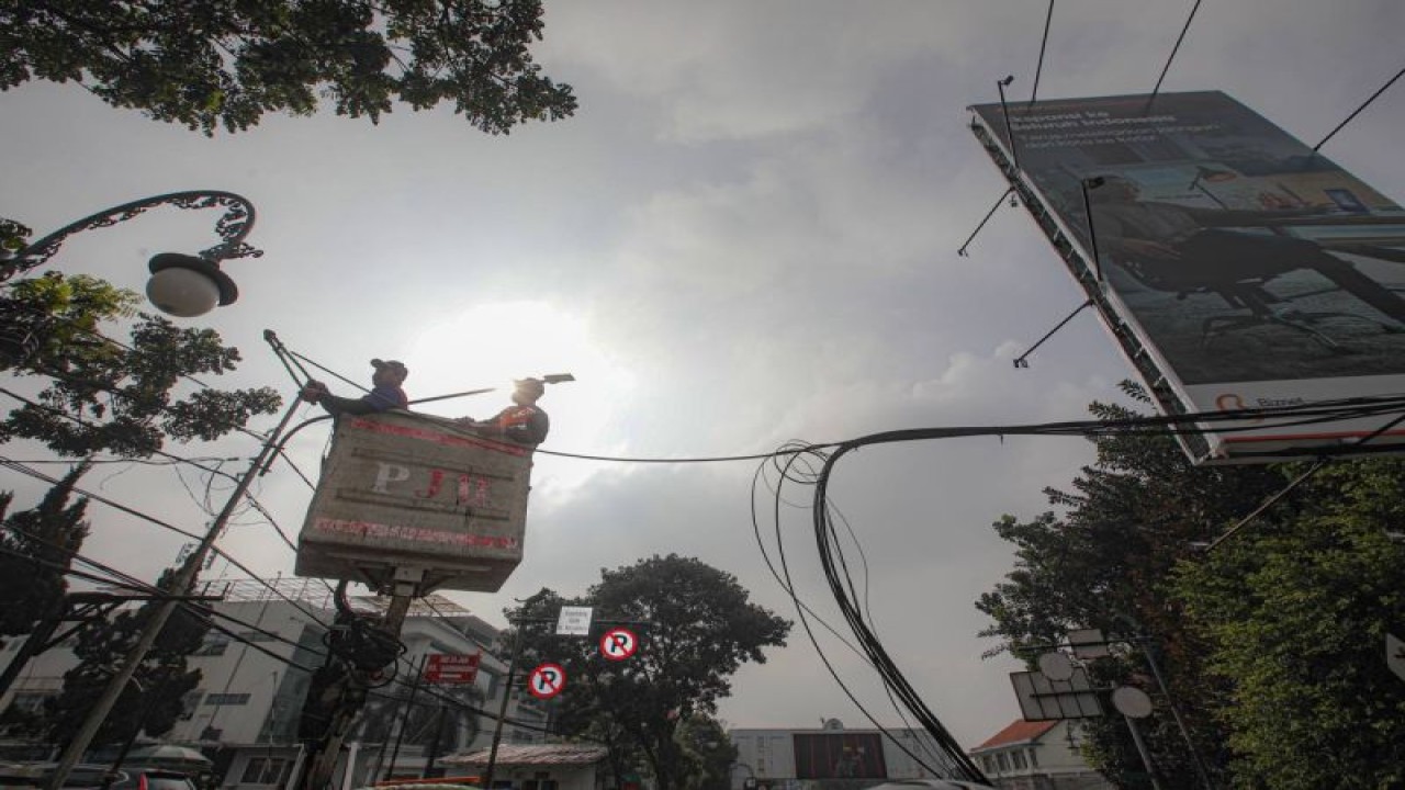 Petugas tengah melakukan pemotongan kabel udara dalam upaya penertiban kabel udara di Jalan Riau, Kota Bandung, Selasa (2/5/2023). (ANTARA/Istimewa)