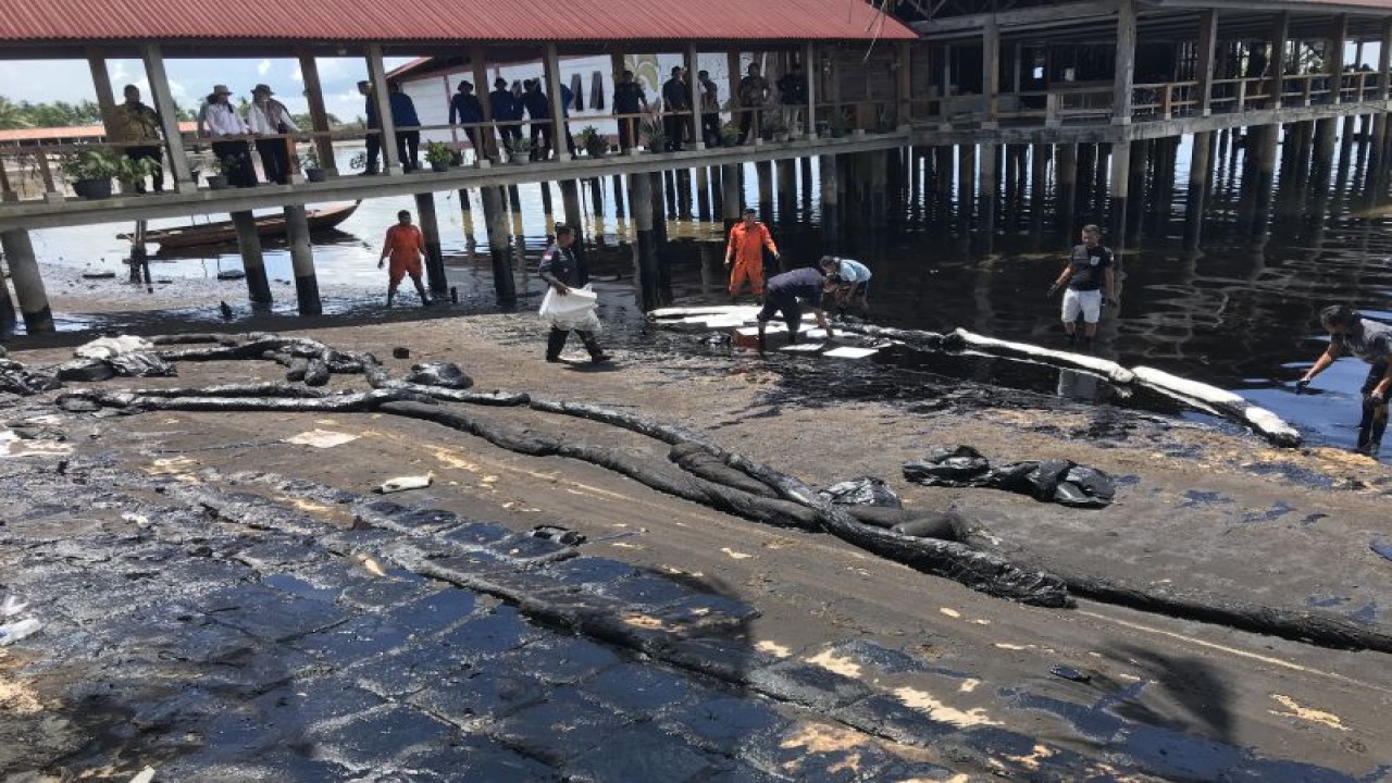 Petugas kebersihan sedang membersihkan limbah minyak hitam yang mencemari Pantai Melayu, Kota Batam, Rabu (3/5). (ANTARA/Yude)