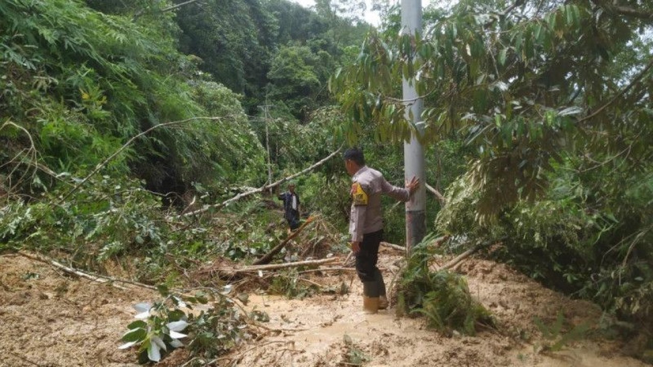 Seorang polisi tengah memegang tonggak listrik di lokasi longsor dan banjir bandang di Nagari Aia Luo, Kecamatan Payung Sekaki, Kabupaten Solok, Sumbar (ANTARA/HO-Humas Pikiran Solok)