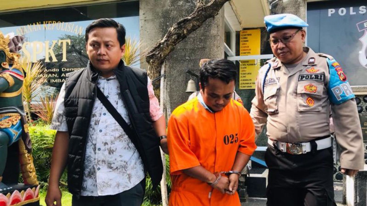 Personel Kepolisian Sektor Kuta menggiring tersangka Agus Budianto yang terlibat kasus penganiyaan terhadap seorang sopir bus di Polsek Kuta, Badung, Bali, Rabu (31/5/2023). ANTARA/Rolandus Nampu