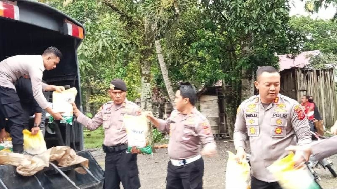 Kapolres Aceh Barat AKBP Pandji Santoso (kanan) memimpin penyaluran bantuan beras bagi masyarakat terdampak banjir di Kecamatan Meureubo, Selasa (9/5/2023). (ANTARA/HO)