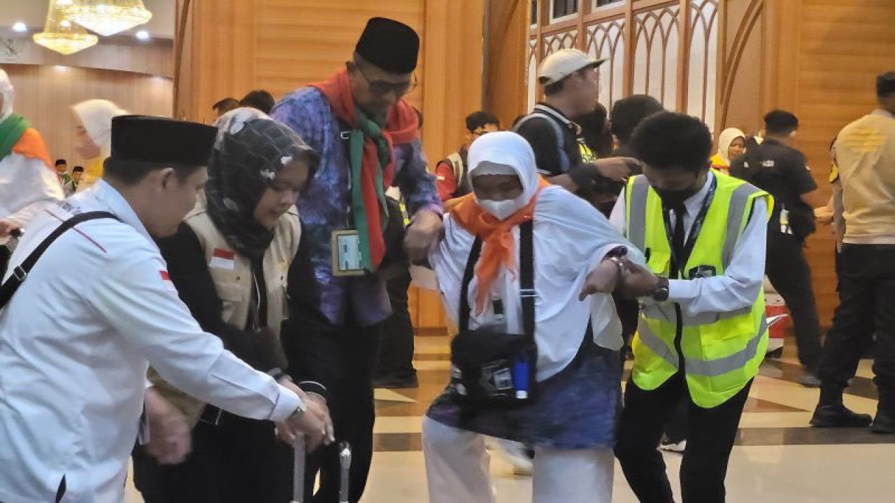 Petugas Panitia Penyelenggara Ibadah Haji (PPIH) melakukan pelayanan kepada jamaah calon haji lansia saat diberangkatkan dari Embarkasi Jakarta, Asrama Haji Pondok Gede, Jakarta, Selasa malam (23/5/23) (ANTARA/Sean Filo Muhamad)