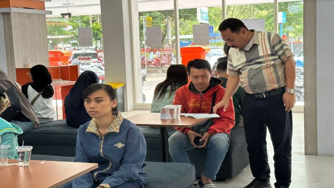 Ketua Satgas Bansos PT Pos Indonesia Hendra Sari (berdiri) saat meninjau penyaluran bansos sembako dan PKH di Kantorpos Cabang Utama (KCU) Malang, Jawa Timur, Minggu (14/5/2023). (Antara/HO/Pos Indonesia)