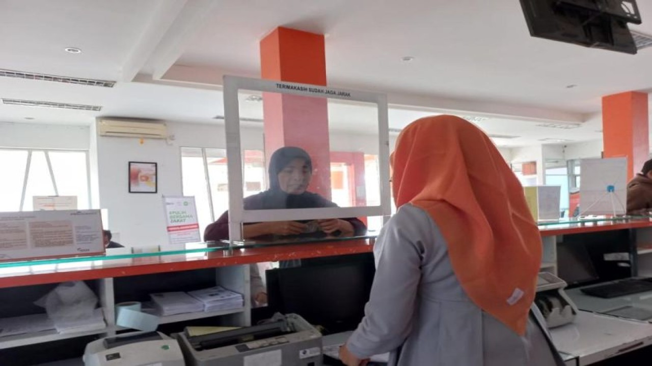 Dokumentasi. Petugas Kantorpos melayani penerima bantuan uang sembako pensiunan PT Pelindo di Jakarta, Selasa (18/4/2023) (Antara/HO/Pos Indonesia)