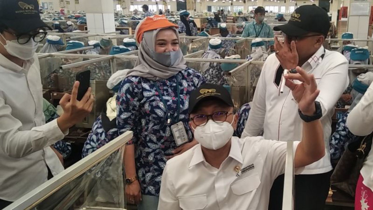 Menteri Perdagangan Zulkifli Hasan menunjukkan rokok hasil buatannya saat mengunjungi pabrik rokok di salah satu gudang produksi rokok Karangbener PT Djarum Kudus, Jawa Tengah, Rabu (28/9/2022). ANTARA/Akhmad Nazaruddin Lathif