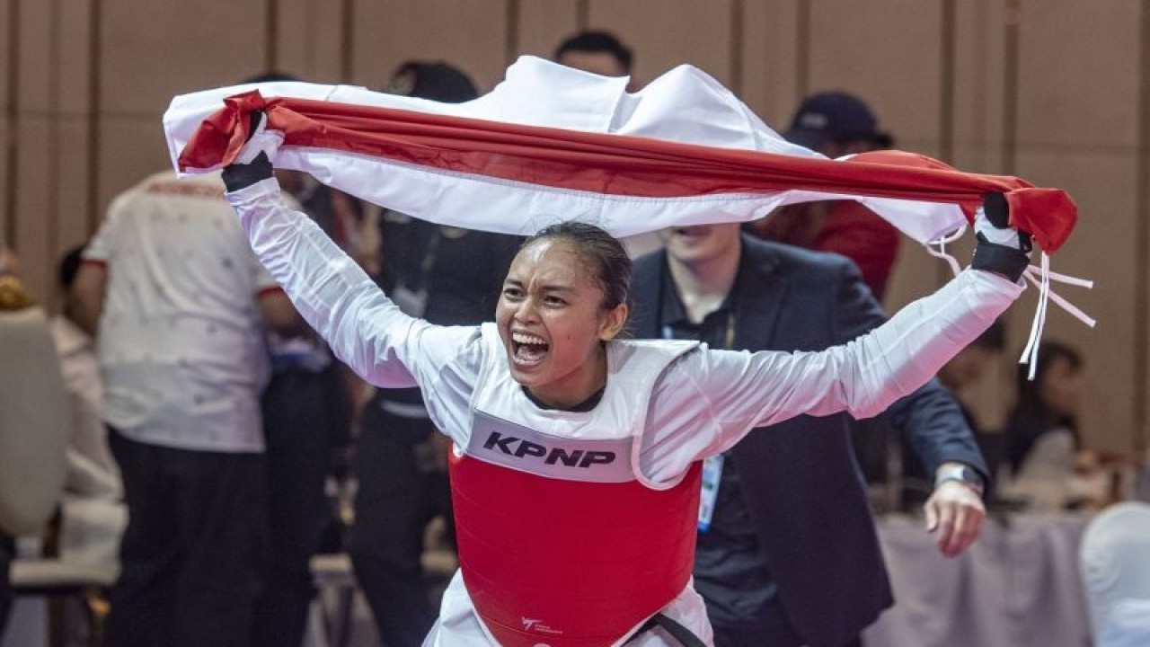 Atlet Taekwondo Indonesia Megawati Tamesti Maheswari melakukan selebrasi sambil membawa bendera merah putih usai menang melawan atlet Taekwondo Thailand Chutikan Jongkolrattanawattana pada pertandingan taekwondo âunderâ 53 kilogram putri SEA Games 2023, di Chory Changvar International Convention and Exibhition Center, Phnom Penh, Kamboja, Senin (15/5/2023). Megawati Tamesti Maheswari berhasil meraih medali emas usai mengalahkan atlet taekwondo Thailand dengan skor 2-1, sementara medali perak diraih atlet taekwondo Thailand Chutikan Jongkolrattanawattana serta medali perunggu diraih atlet taekwondo Filipina Baby Jessica Canabal dan atlet taekwondo Kamboja Mam Julie. ANTARA FOTO/Muhammad Adimaja/hp (ANTARA FOTO/MUHAMMAD ADIMAJA)