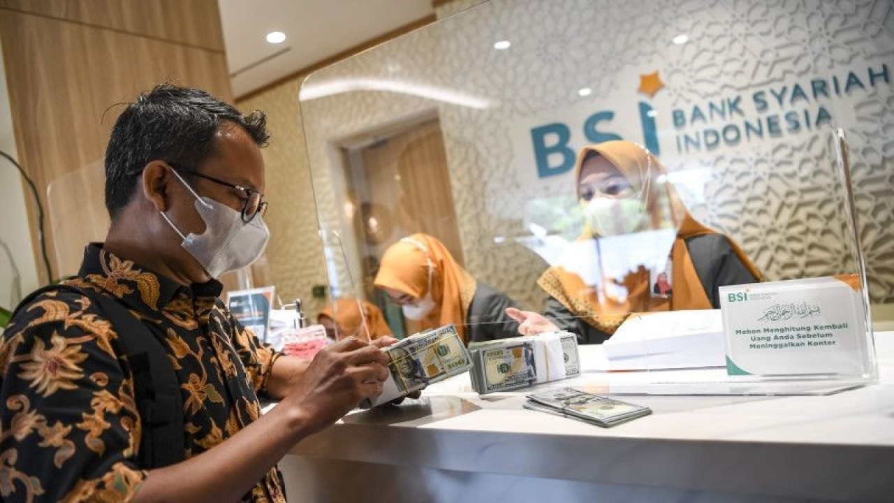 Nasabah membawa uang dolar AS usai bertransaksi di Kantor Cabang BSI Jakarta Thamrin, Jakarta, Kamis (11/5/2023). ANTARA FOTO/M Risyal Hidayat/tom.