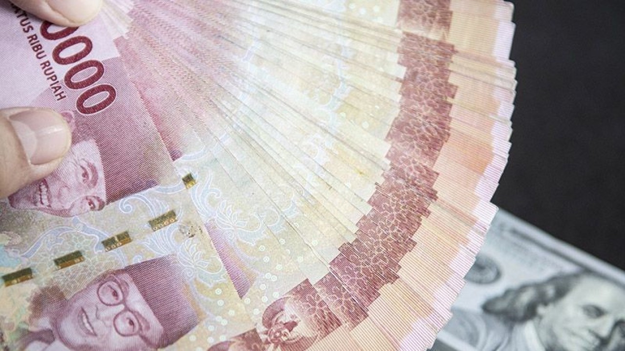 Ilustrasi - Petugas menunjukan uang pecahan rupiah dan dolar AS di gerai penukaran mata uang asing VIP (Valuta Inti Prima) Money Changer, Jakarta, Selasa (3/1/2023). ANTARA FOTO/Muhammad Adimaja/foc/pri.