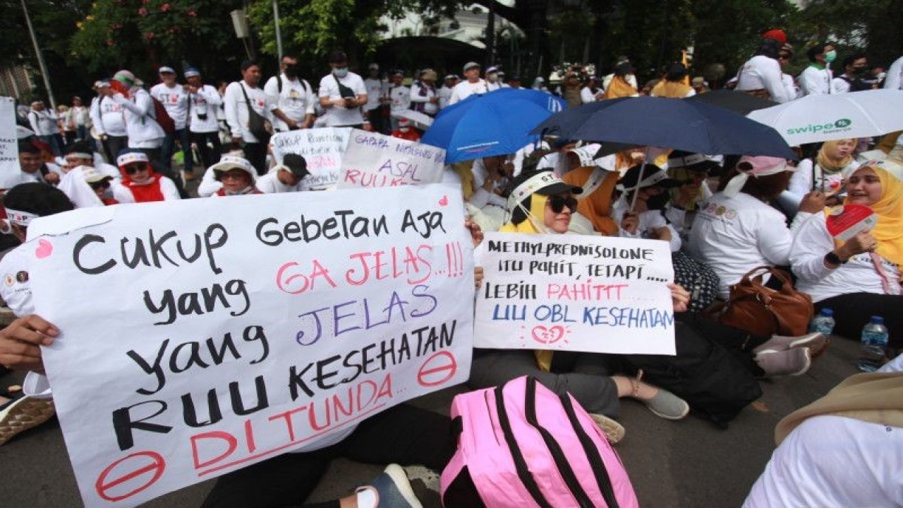 Pengunjuk rasa mengangkat poster penolakan Rancangan Undang-Undang (RUU) Omnibus Law Kesehatan saat aksi di kawasan Patung Kuda Arjuna Wiwaha, Jakarta, Senin (8/5/2023). ANTARA FOTO/Reno Esnir/rwa. (ANTARA FOTO/RENO ESNIR)