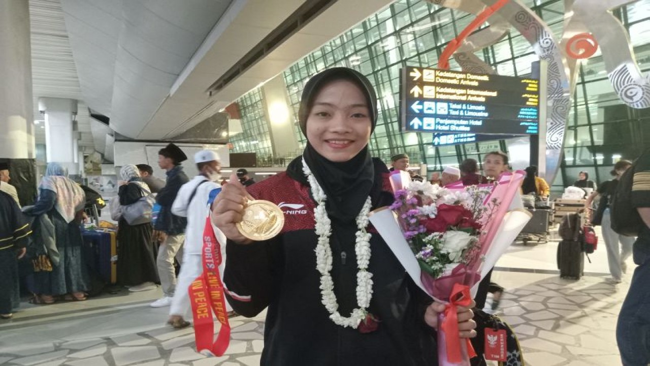 Pesilat Indonesia Safira Dwi Meilani berpose setelah mengikuti upacara penjemputan atlet SEA Games di Bandara Soekarno-Hatta, Tangerang, Kamis (11/5/2023). (ANTARA/RAUF ADIPATI)
