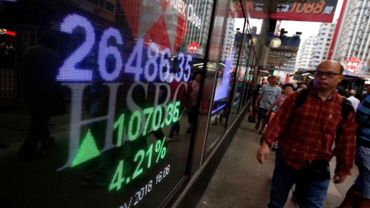 Ilustrasi - Seorang pejalan kaki melihat layar pergerakan perdagangan saham Indeks Hang Seng di Hong Kong, China. ANTARA/REUTERS/Bobby Yip/am.