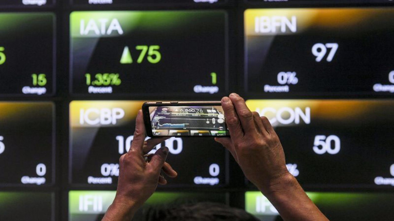 Pekerja memotret layar yang menampilkan pergerakan Indeks Harga Saham Gabungan (IHSG) di Bursa Efek Indonesia, Jakarta, Rabu (26/4/2023). ANTARA FOTO/Hafidz Mubarak A/foc.