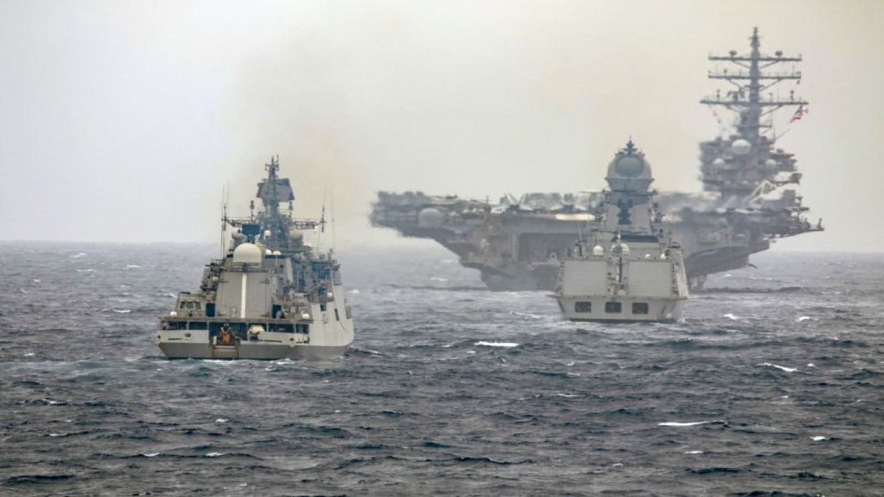 Kapal induk Angkatan Laut Amerika Serikat, USS Ronald Reagan (CVN 76) (tengah), dalam formasi perang bersama kapal perang INS Kochi dan fregat INS Teg dari Angkatan Laut India dalam latihan gabungan Angkatan Laut India dan Amerika Serikat di Samudera Hindia pada 24 Juni 2021. (Angkatan Laut Amerika Serikat/US Navy via Flickr)