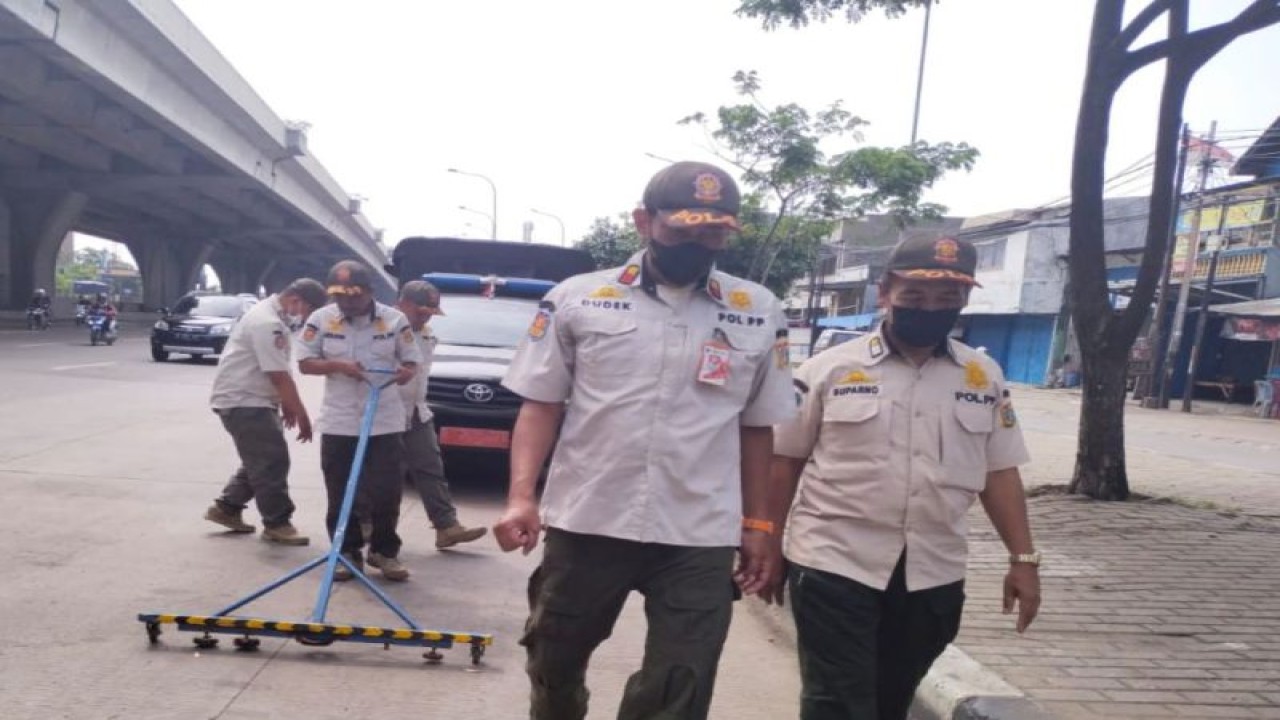 Petugas Satpol PP Jakarta Utara menyapu ranjau paku di Jalan Perintis Kemerdekaan, Kawasan Kelapa Gading, Jakarta Utara, Rabu (3/5/2023). ANTARA/HO-Kominfotik Jakarta Utara